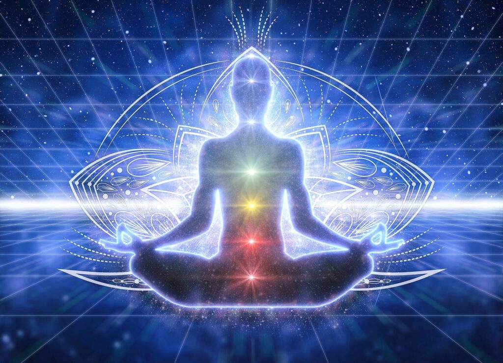 Silhouette meditating with glowing chakras and cosmic background.
